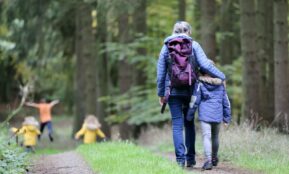 woman in blue denim jeans and black jacket walking with woman in green jacket