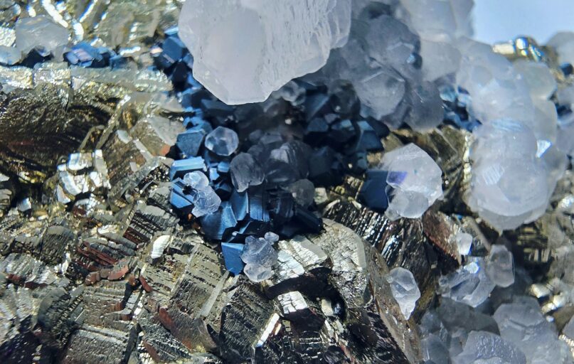 Close-up of metallic pyrite crystals with quartz and blue minerals
