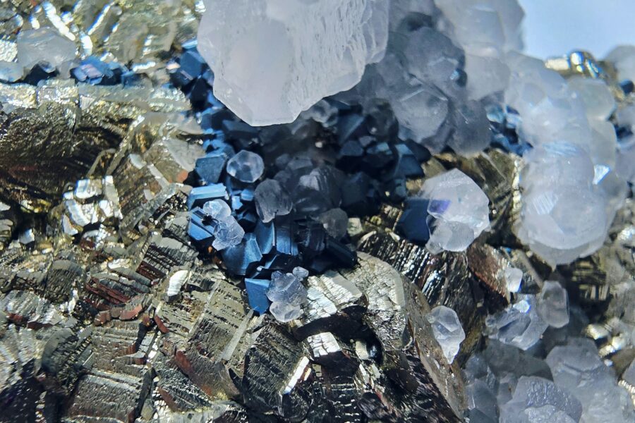 Close-up of metallic pyrite crystals with quartz and blue minerals