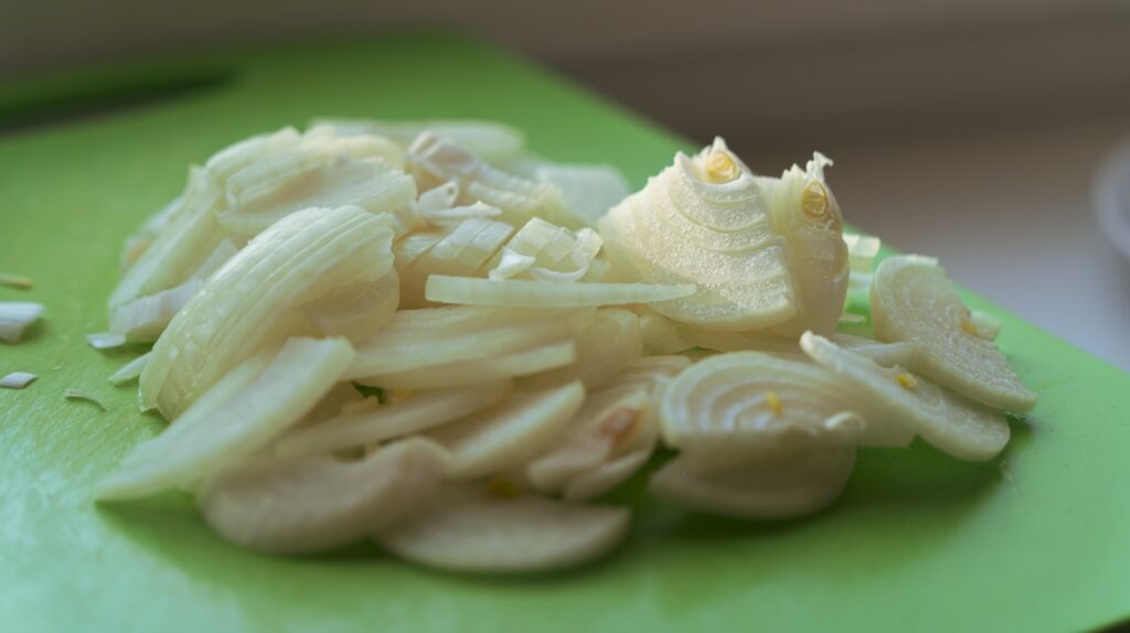 Sliced onions on a green cutting board