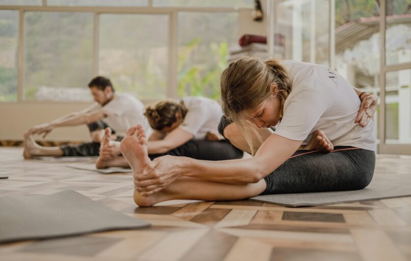 a group of people doing yoga in a room