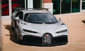 a silver bugatti is parked in front of a building