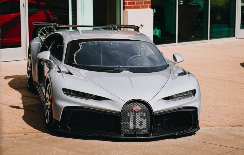 a silver bugatti is parked in front of a building