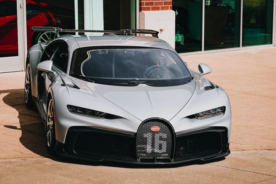 a silver bugatti is parked in front of a building