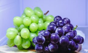 a bunch of grapes sitting on top of a cutting board