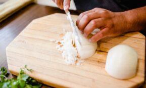 a person chopping onions on a cutting board