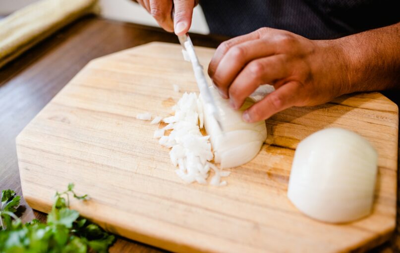 a person chopping onions on a cutting board