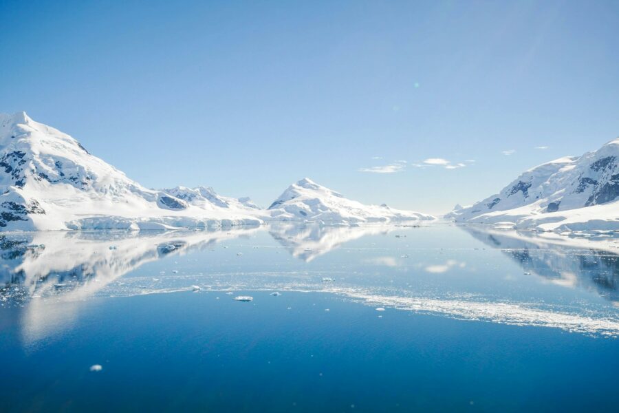 mountain with snow near body of water