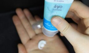 person holding white and blue plastic tube bottle