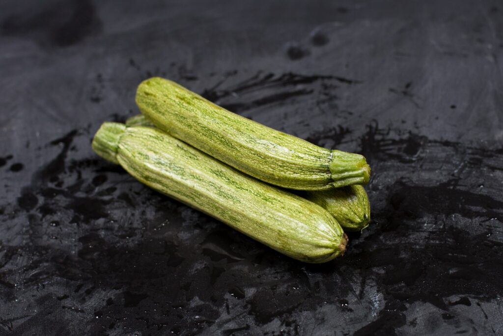 A couple of cucumbers sitting on top of a black surface