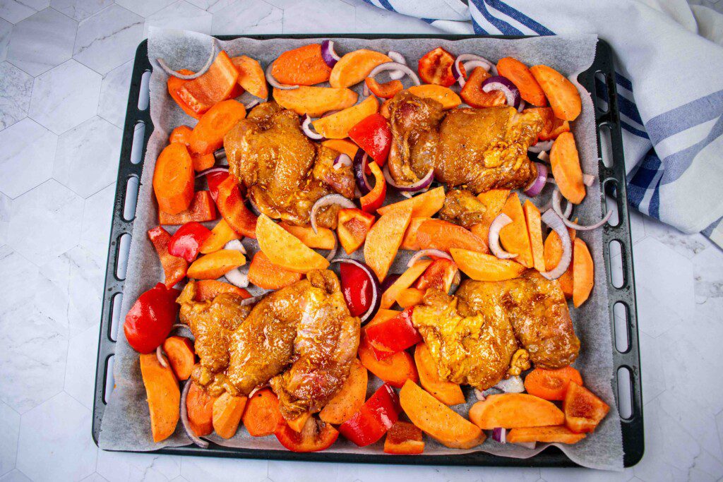 Žemės riešutų kremo vištiena su keptomis daržovėmis. Skardoje