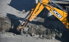 Yellow excavator digging in the dirt