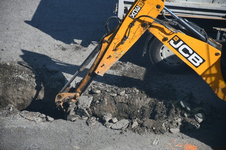 Yellow excavator digging in the dirt