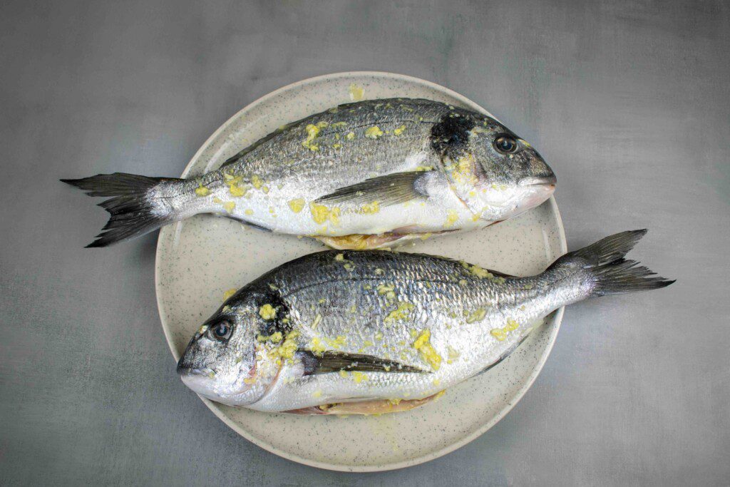 Orkaitėje kepta dorada su daržovių padažu. ištepta