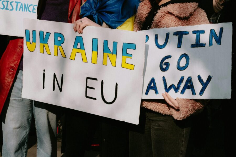 Protest with signs supporting Ukraine in EU and opposing Putin. Capturing a social movement outdoors.
