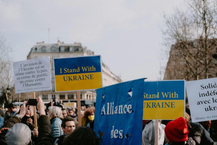 A peaceful demonstration featuring protestors with signs supporting Ukraine against invasion.