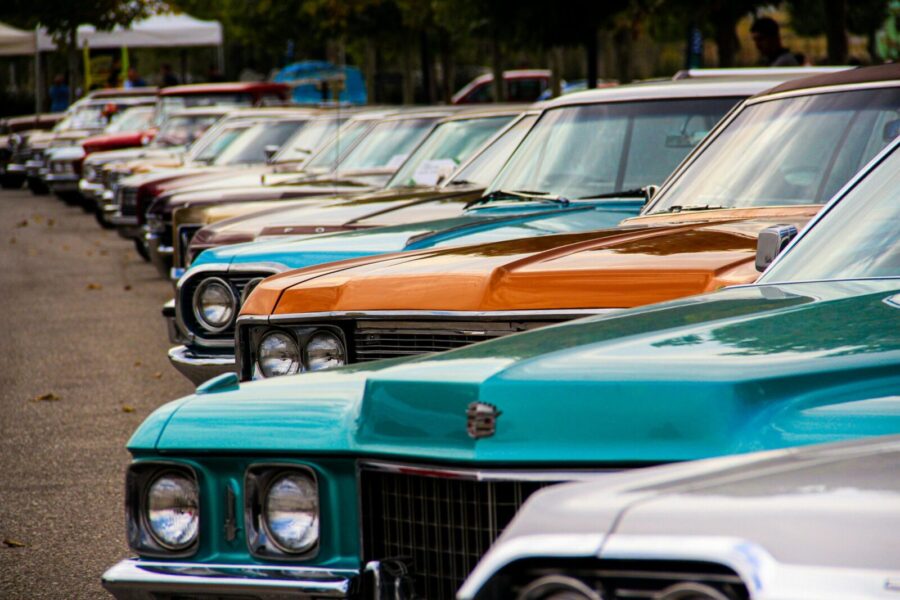 A row of classic vintage cars displayed outdoors. Perfect for car enthusiasts and retro themes.