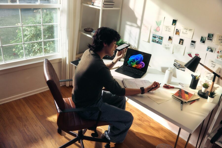 Person working at a desk with a laptop and books.