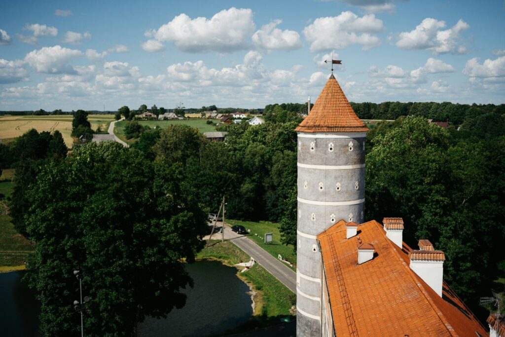 A tower and roof against a backdrop of nature.