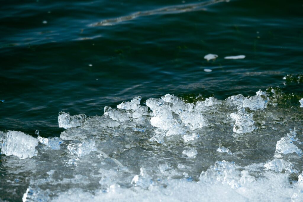 Detailed image of frozen ice formations meeting dark water in a winter setting.