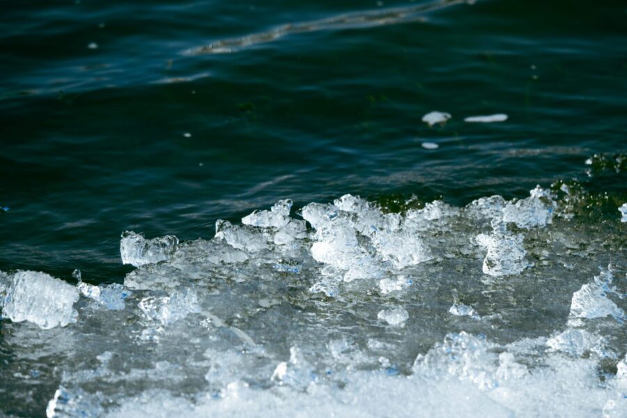 Detailed image of frozen ice formations meeting dark water in a winter setting.