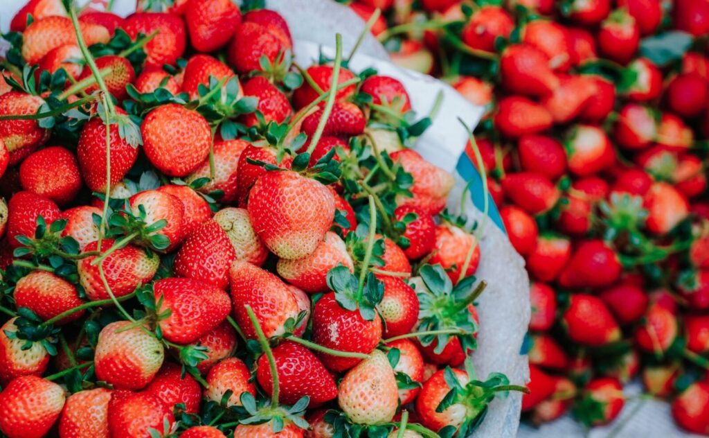 Close-up of fresh, ripe strawberries in a market setting showcasing vibrant red colors.