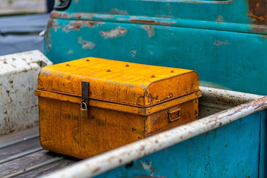 Yellow chest in a vintage truck bed with a weathered, rustic appearance.